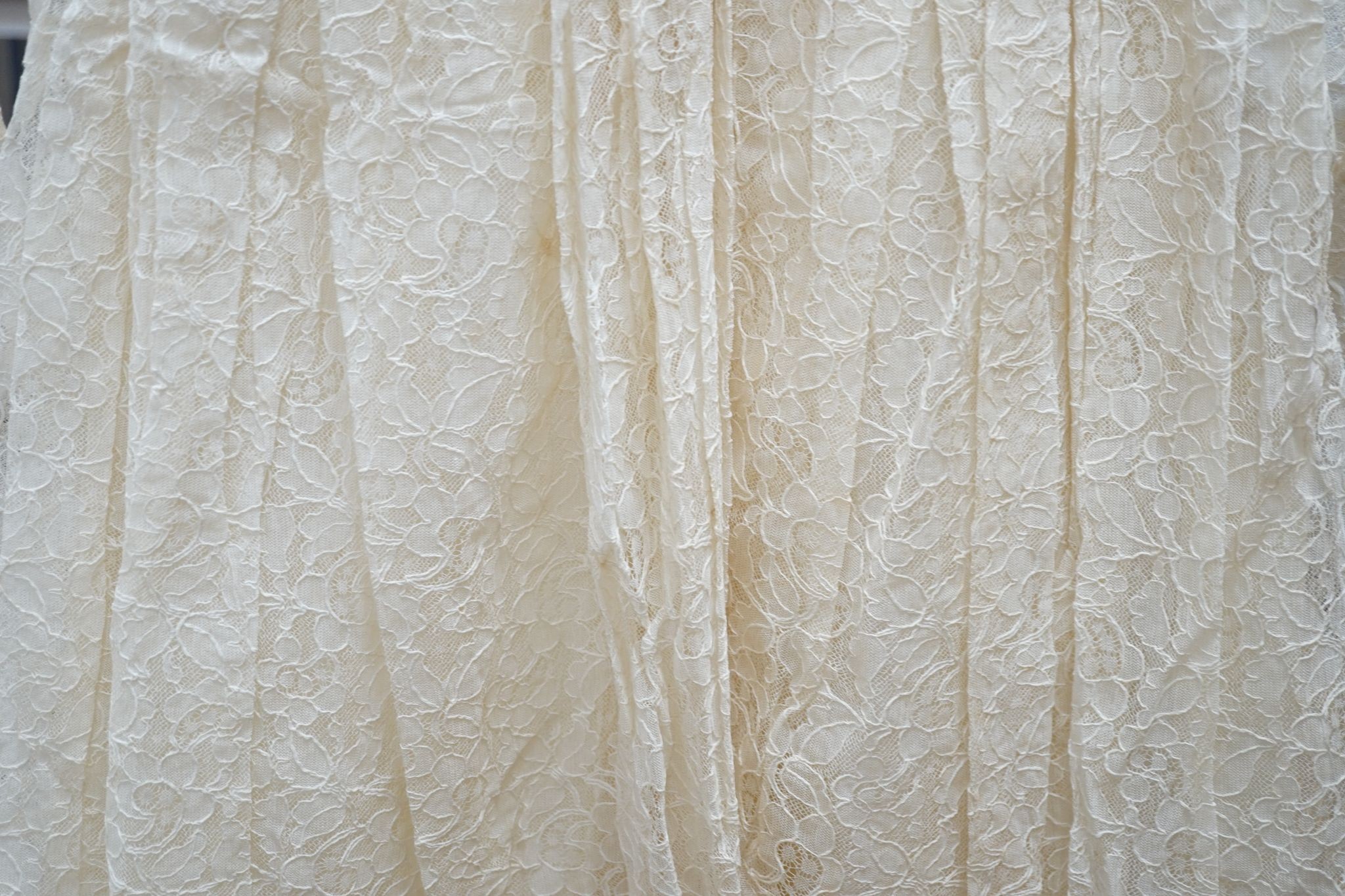A late 1930's- 40's cream machine lace wedding dress and petticoat together with a pear listed floral tiara/ headdress.